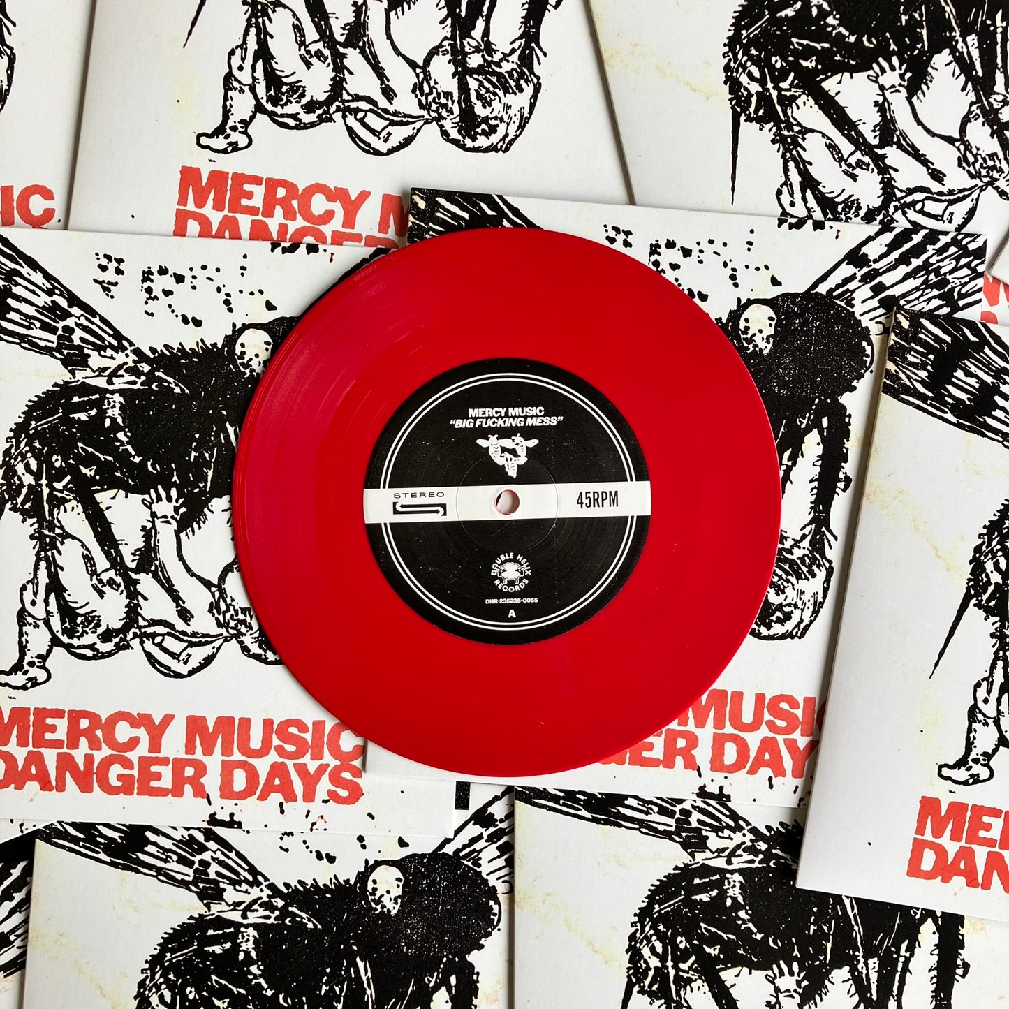Red vinyl record with 'Mercy Music Danger Days' on a background of album covers.
