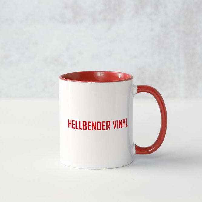White mug with red interior and handle featuring 'HELLBENDER VINYL' text on a light gray background