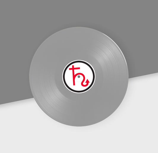 A metallic silver 12-inch vinyl record with a red and black label in the center, placed on a two-tone background with gray at the top and white at the bottom.