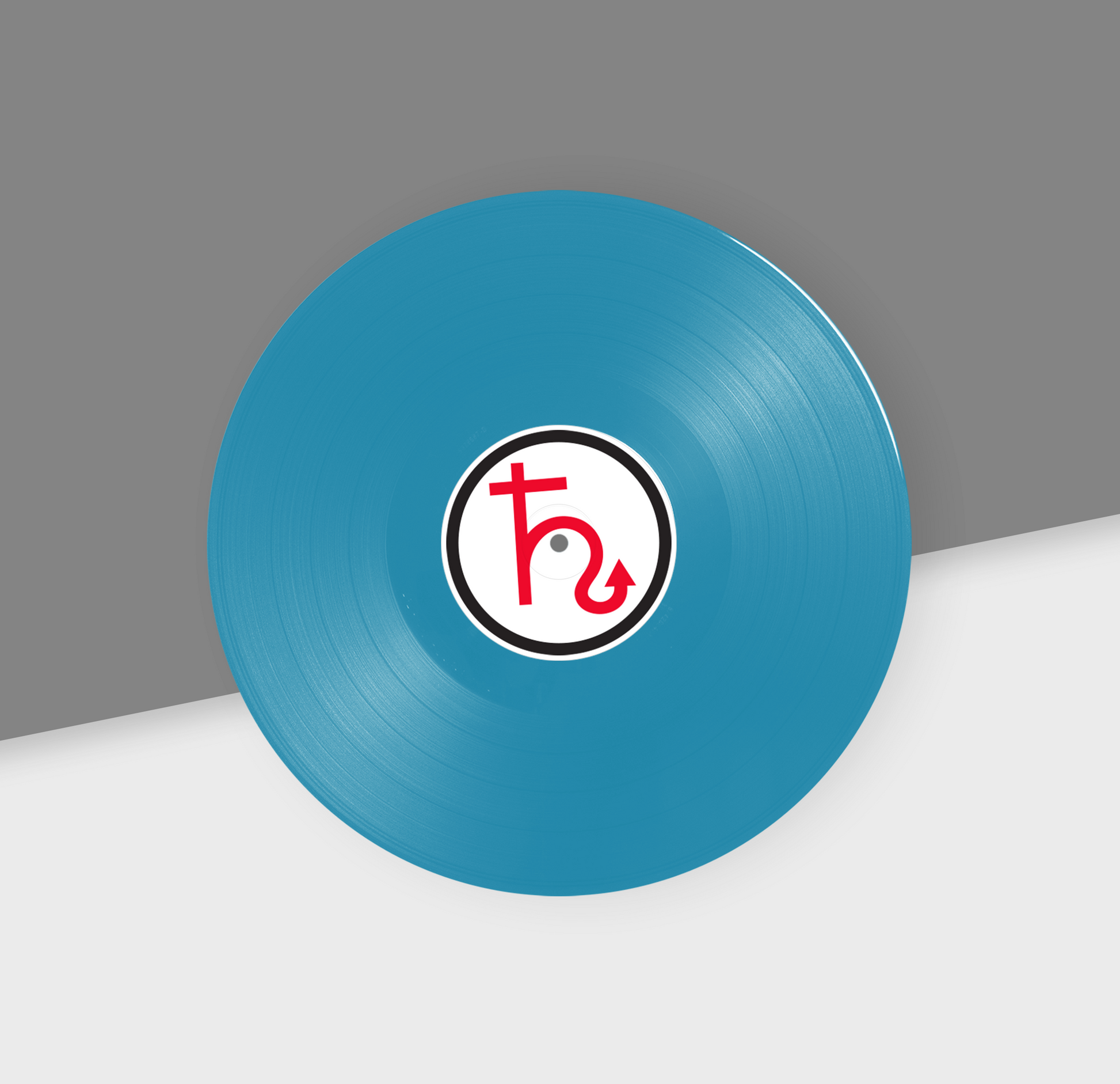 A turquoise colored 12-inch vinyl record with a white label in the center featuring a red and black design.