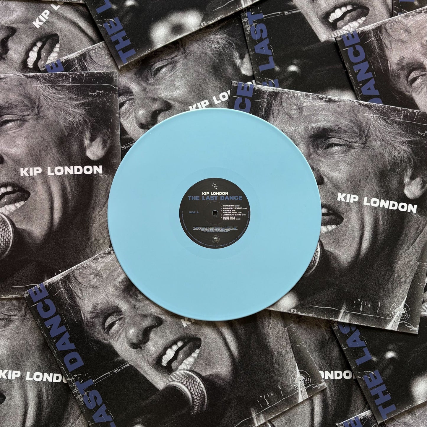 Sky blue vinyl record with Kip London branding on a collage of black and white album covers.