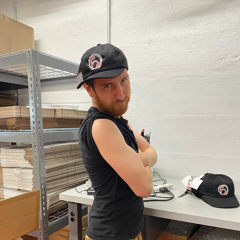 Press operator Nick wearing a Hellbender Vinyl baseball cap