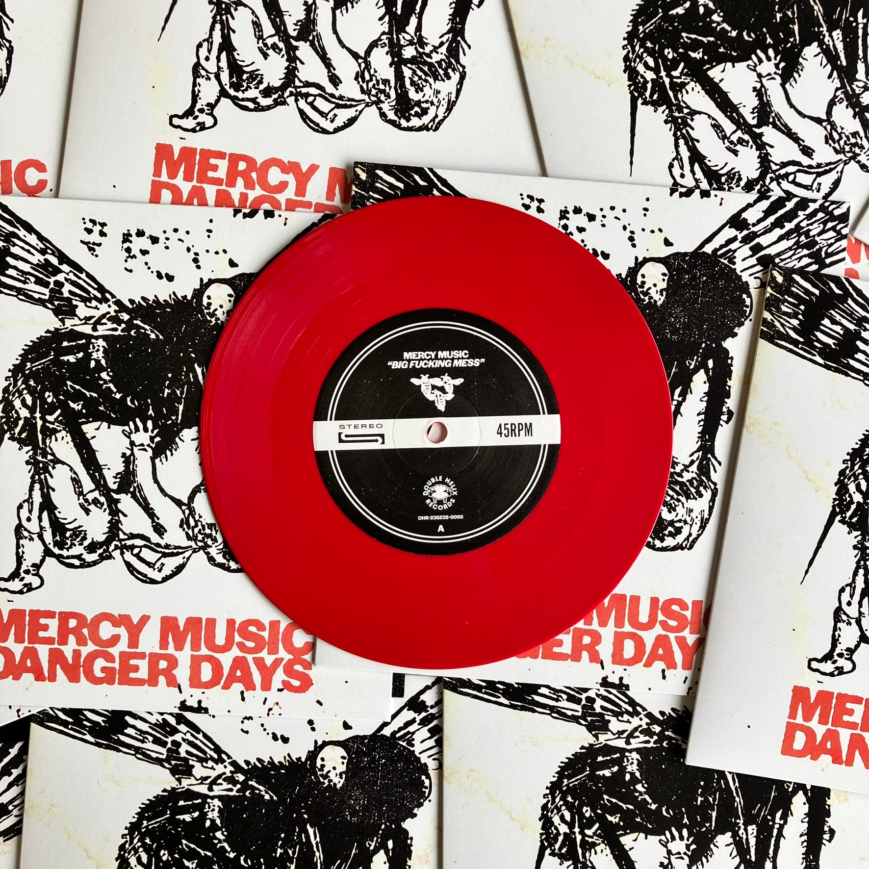 Red vinyl record with 'Mercy Music Danger Days' on a background of album covers.