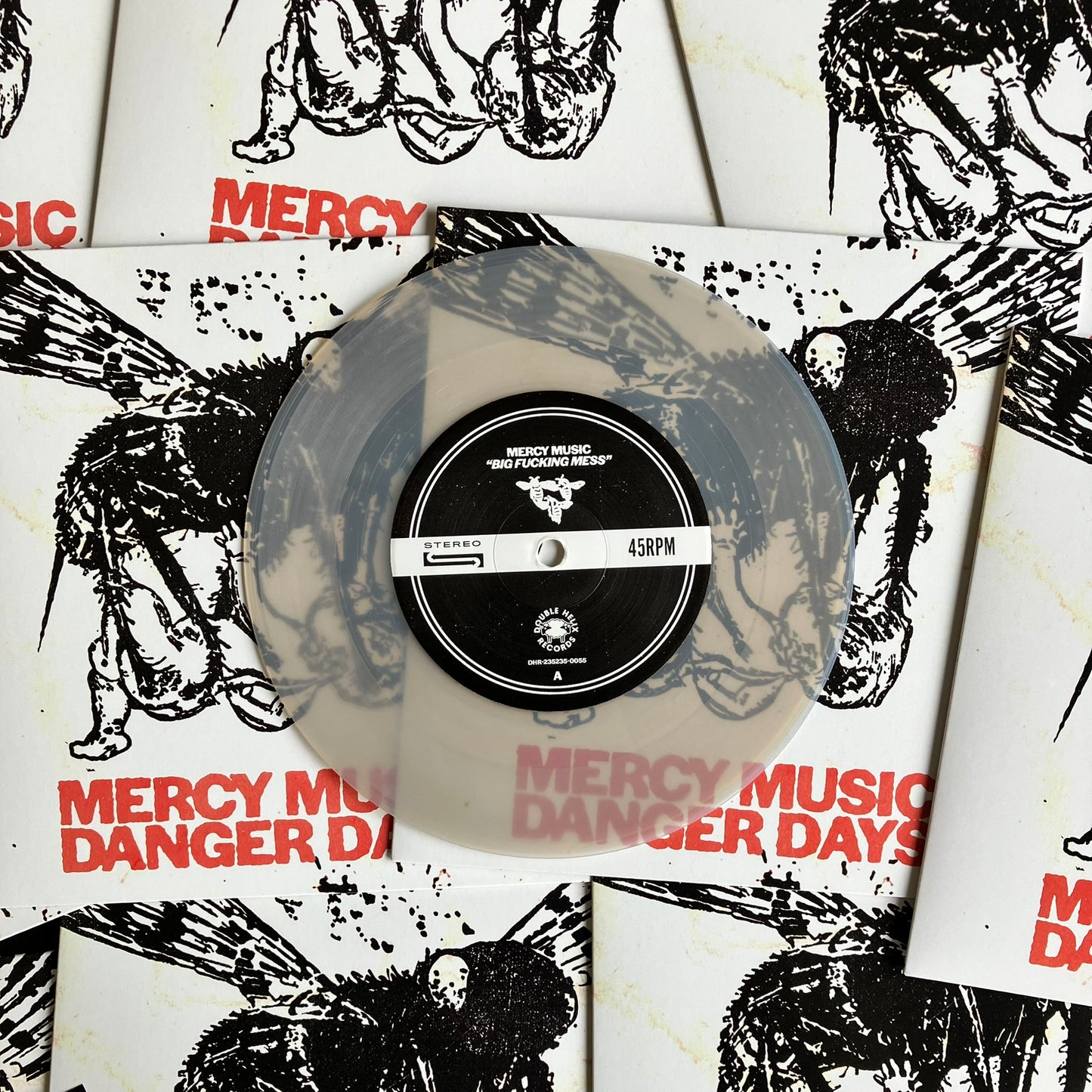 Frosted glass clear vinyl record with a black label on a white background with black and red text and graphics.