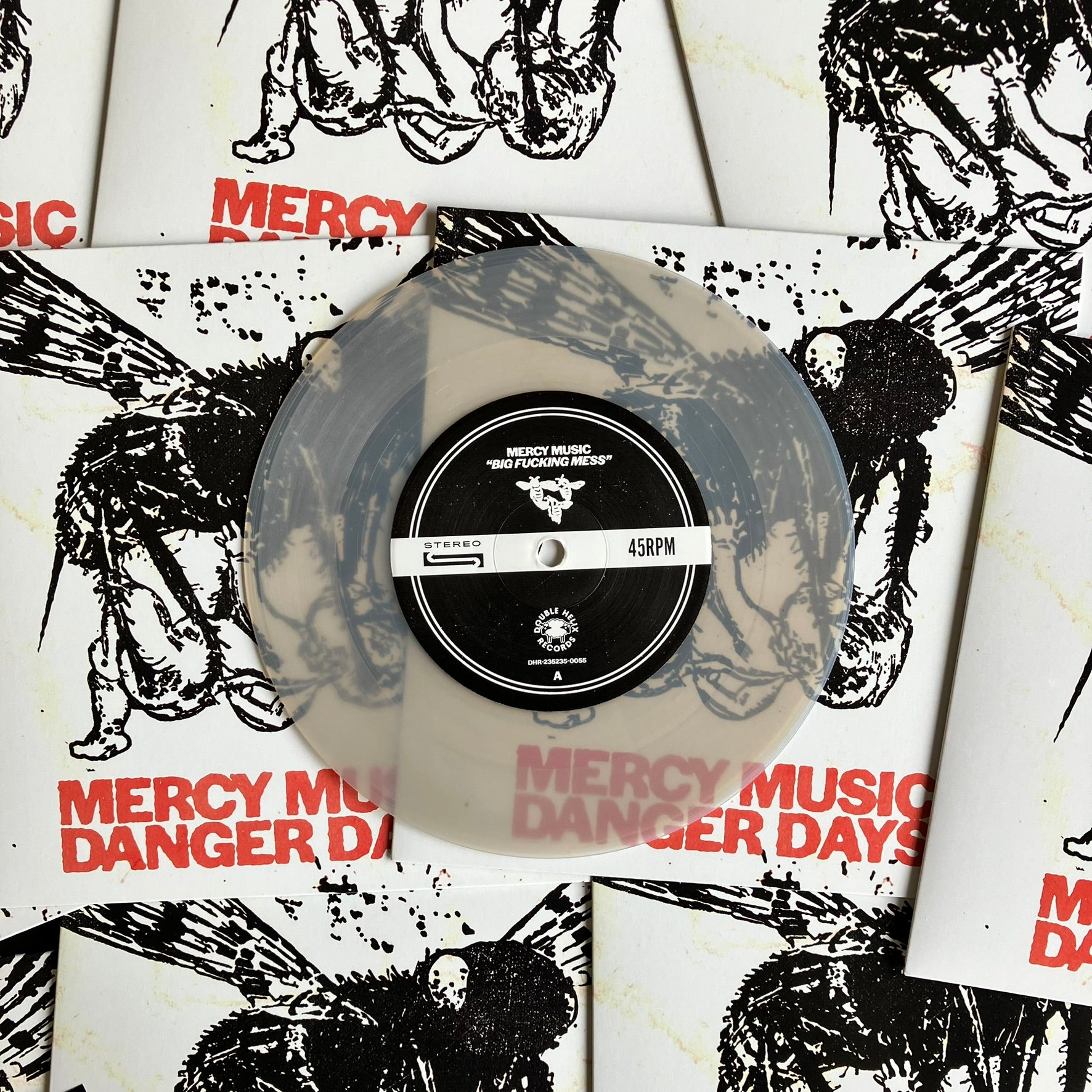 Frosted glass clear vinyl record with a black label on a white background with black and red text and graphics.