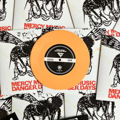 Vinyl record with peach-colored disc and black label on Mercy Music album covers.